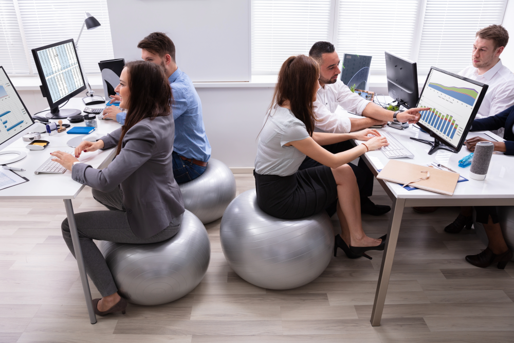 workplace wellness - employees sitting on exercise balls at their desks.