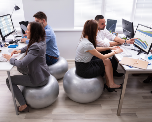 workplace wellness - employees sitting on exercise balls at their desks.